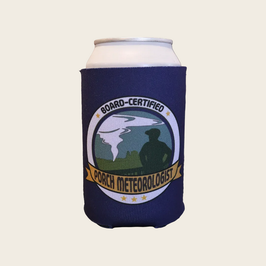 A navy blue can cooler sleeve on a white can, featuring a circular 'Board-Certified Porch Meteorologist' graphic with a tornado illustration and a silhouetted figure.