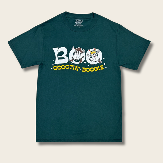 A green t-shirt with a white graphic of two ghosts in cowboy boots dancing through the text "BOO SCOOTIN' BOOGIE" on a cream background.
