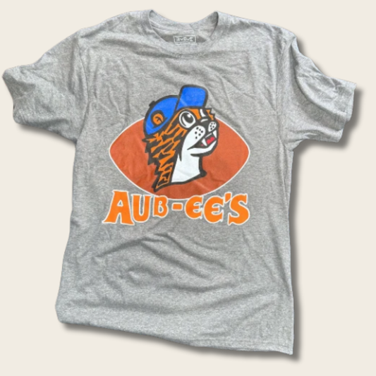 A heather gray short-sleeve t-shirt featuring a vintage-style graphic of a tiger mascot wearing a blue cap inside an orange shape, with the text 'AUB-EE'S' printed below in orange.