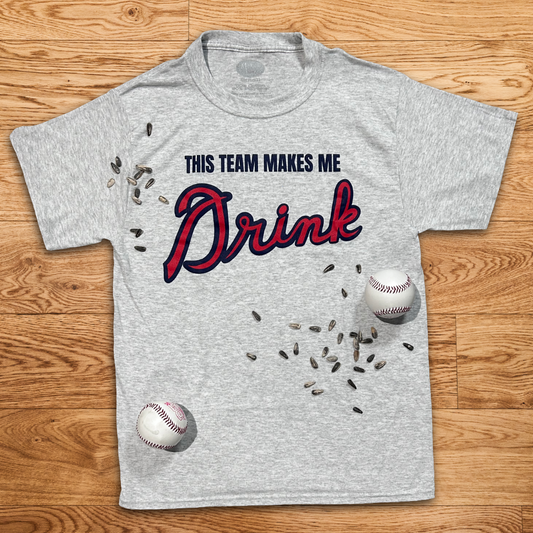 Funny Atlanta baseball shirt with This Team Makes Me Drink text on gray t-shirt with baseball props on wood background