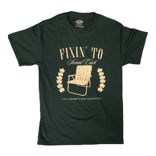 Dark green Fixin’ To Social Club t-shirt with lawn chair graphic and vintage text on white background